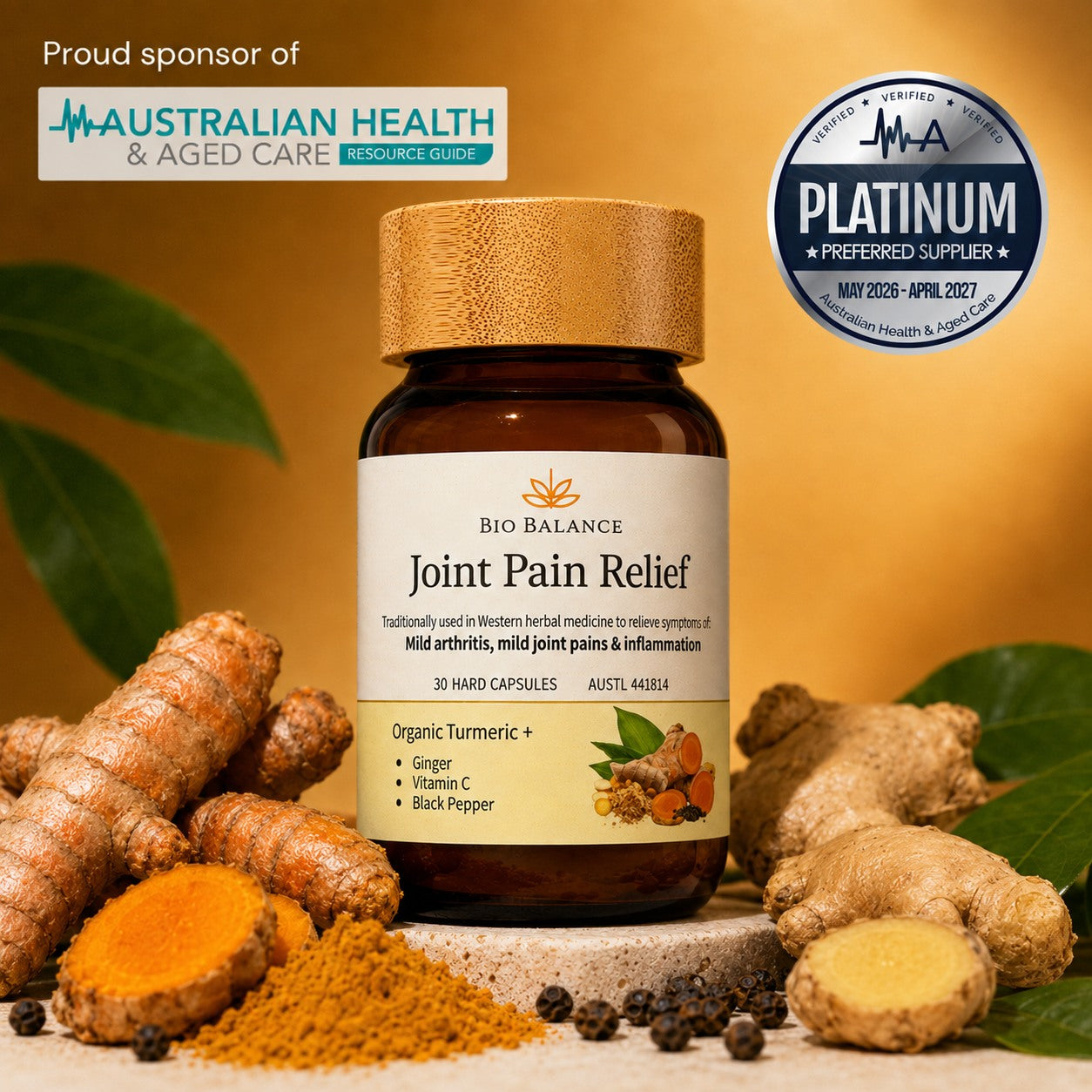 Bio Balance Joint Pain Relief supplement bottle with a gold cap, surrounded by turmeric roots, turmeric powder, black peppercorns, and green leaves on a warm golden background. Includes Australian Health & Aged Care sponsor badge and Platinum Supplier badge.