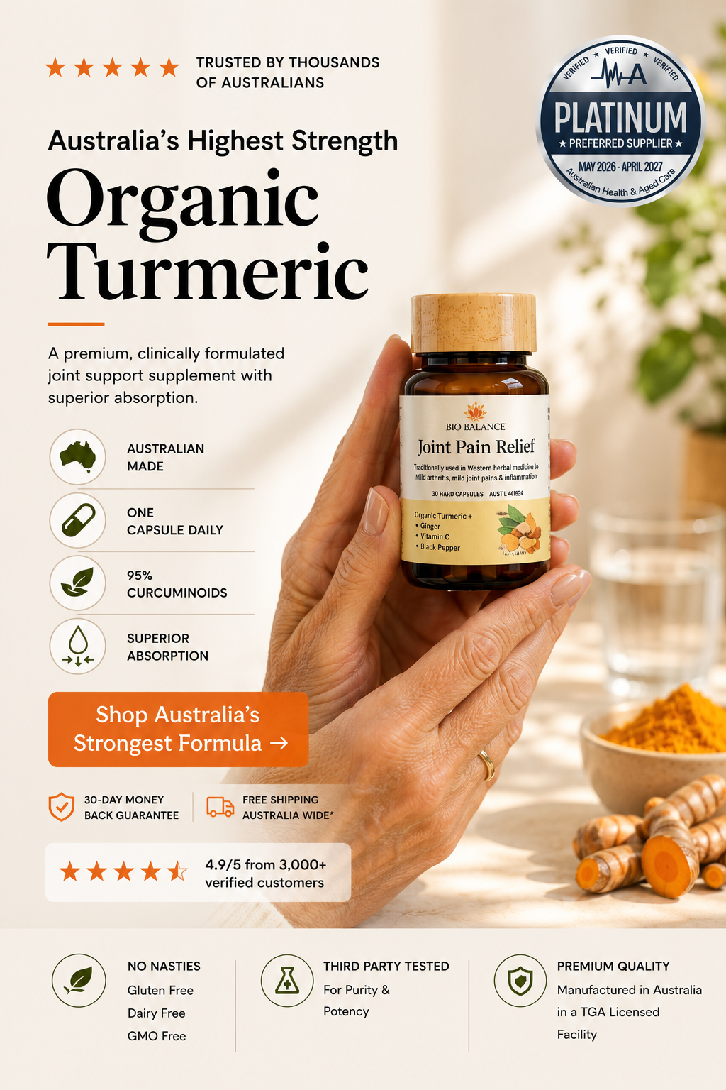 A hand holds a small amber bottle of VelaPlatinum Organic Turmeric Joint Pain Relief supplement against a warm, softly blurred background with turmeric roots and herbs. The image is a promotional graphic with text highlighting 'Australia's Highest Strength Organic Turmeric' and product benefits.